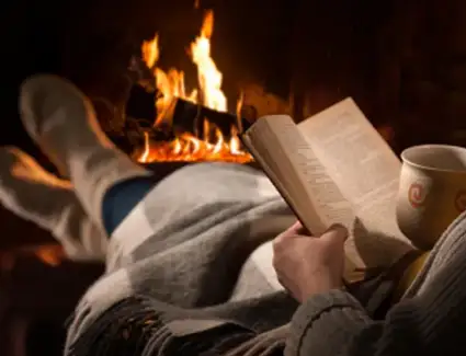 Man in Toledo sitting comfortably by a fireplace after Shamy Heating & Air Conditioning fixed his furnace.